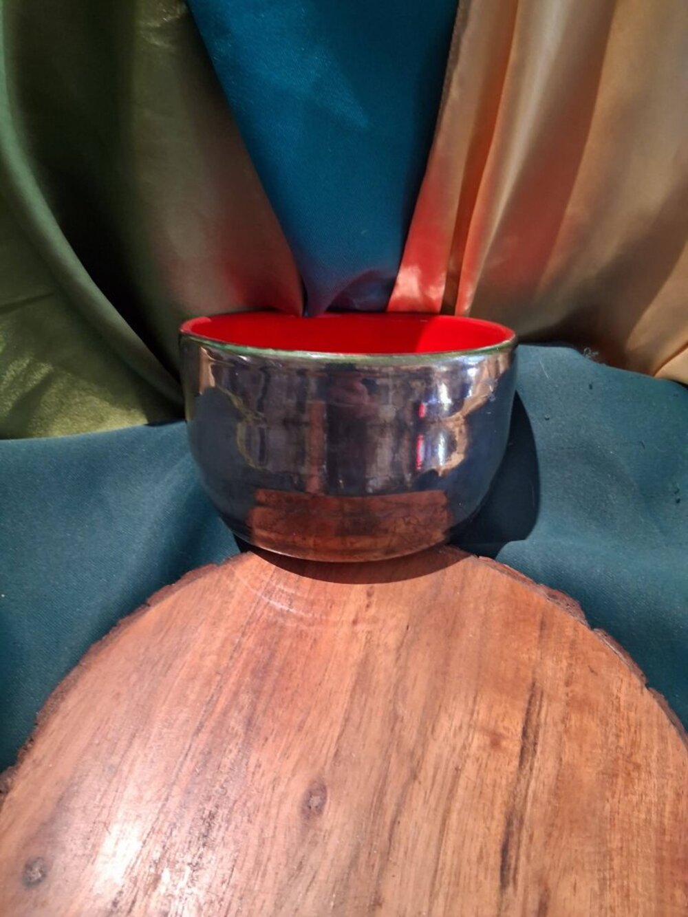 Vintage studio pottery bowl featuring a vibrant, glossy red interior glaze